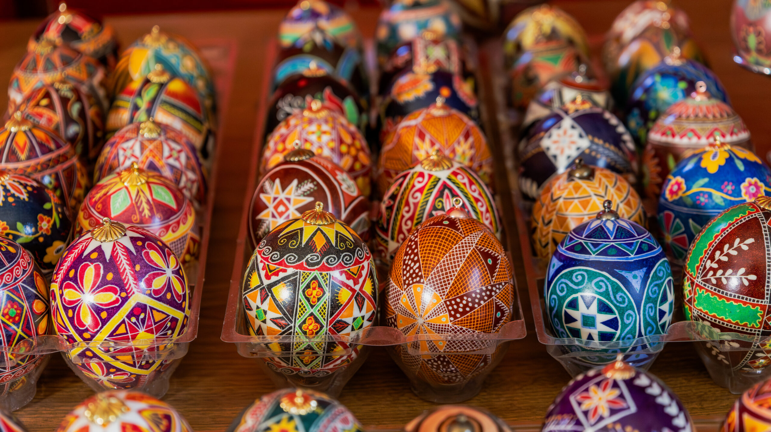 Trays filled with colorful, intricate wax-resist patterned eggs