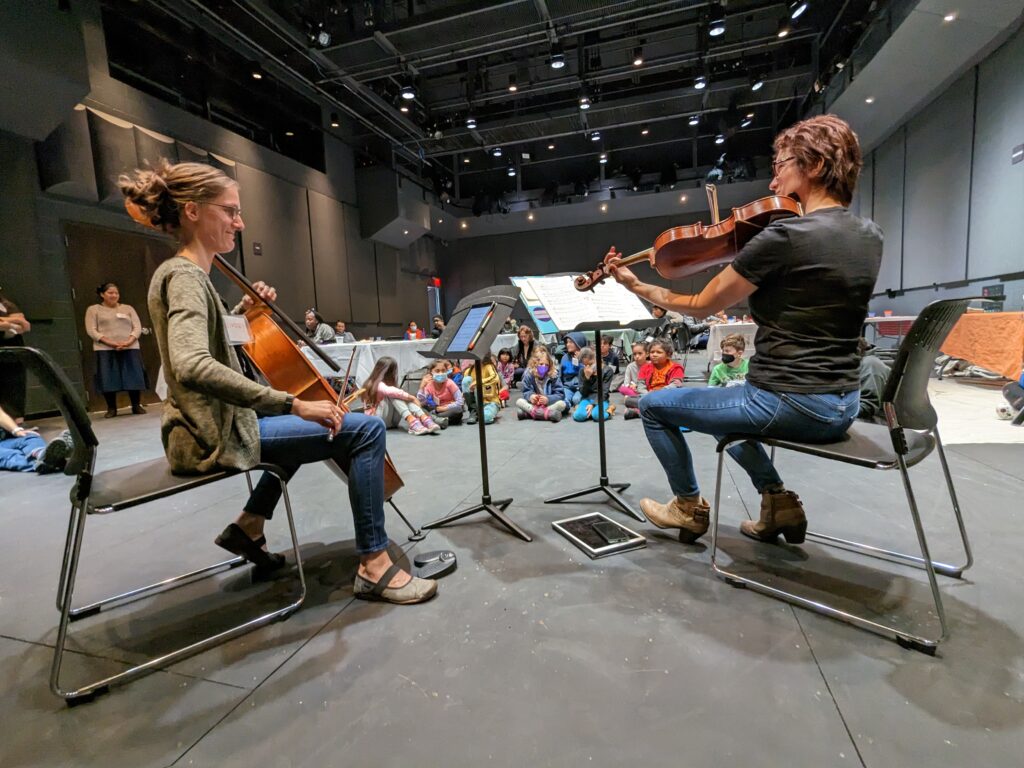 Musicians perform for a group of students.
