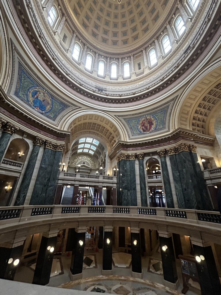A ornate building with marble pillars and a high domed ceiling