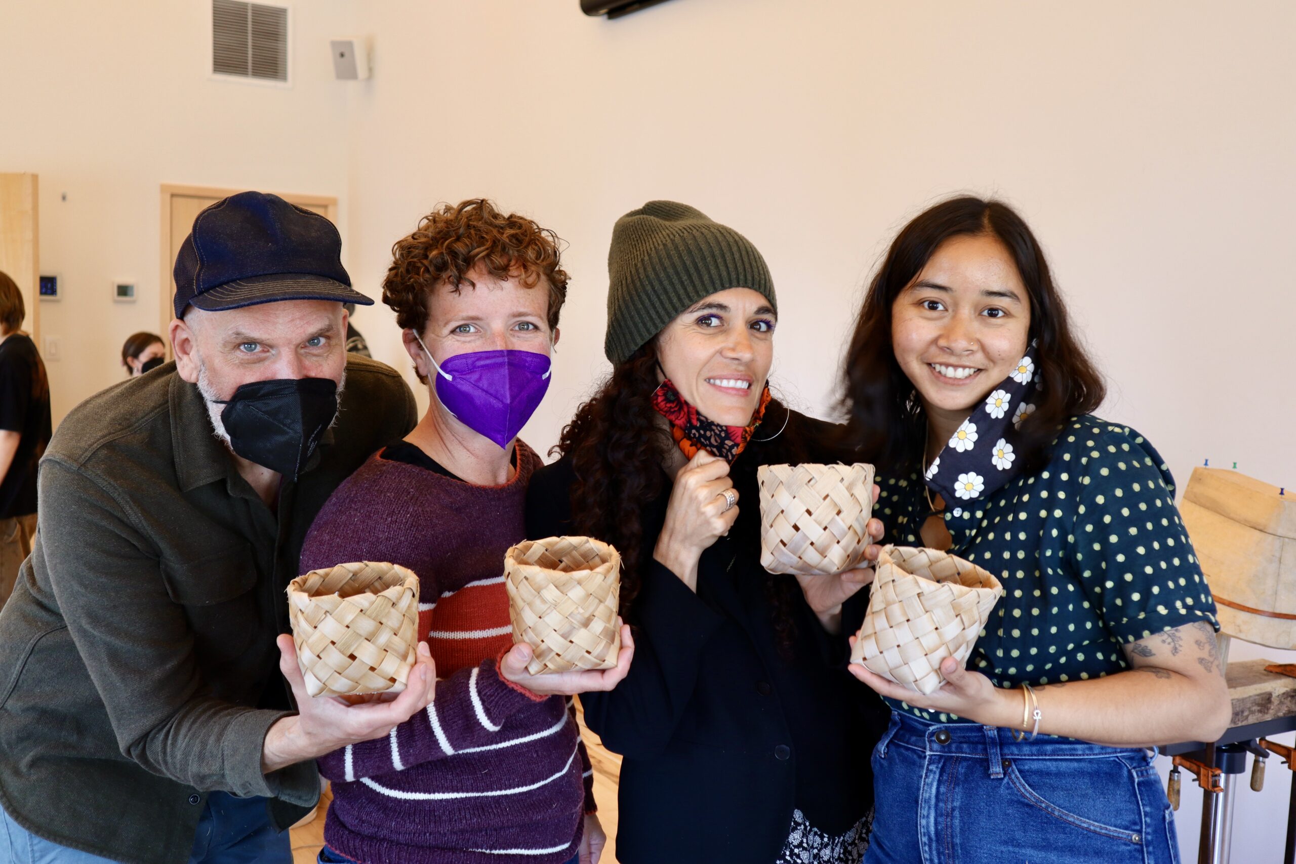 Four people pose with baskets.