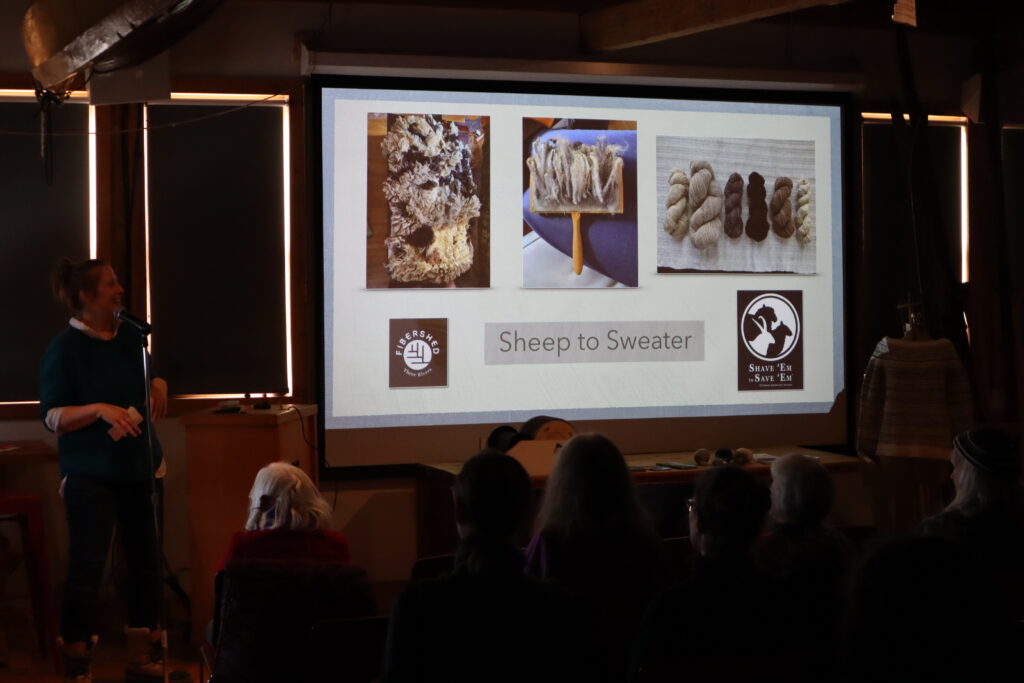 People in a room looking at a large presentation called "Sheep to Sweater."