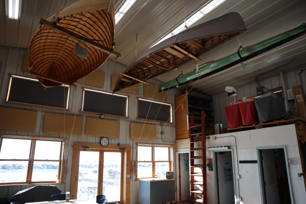 Canoes hanging from a ceiling in a room.