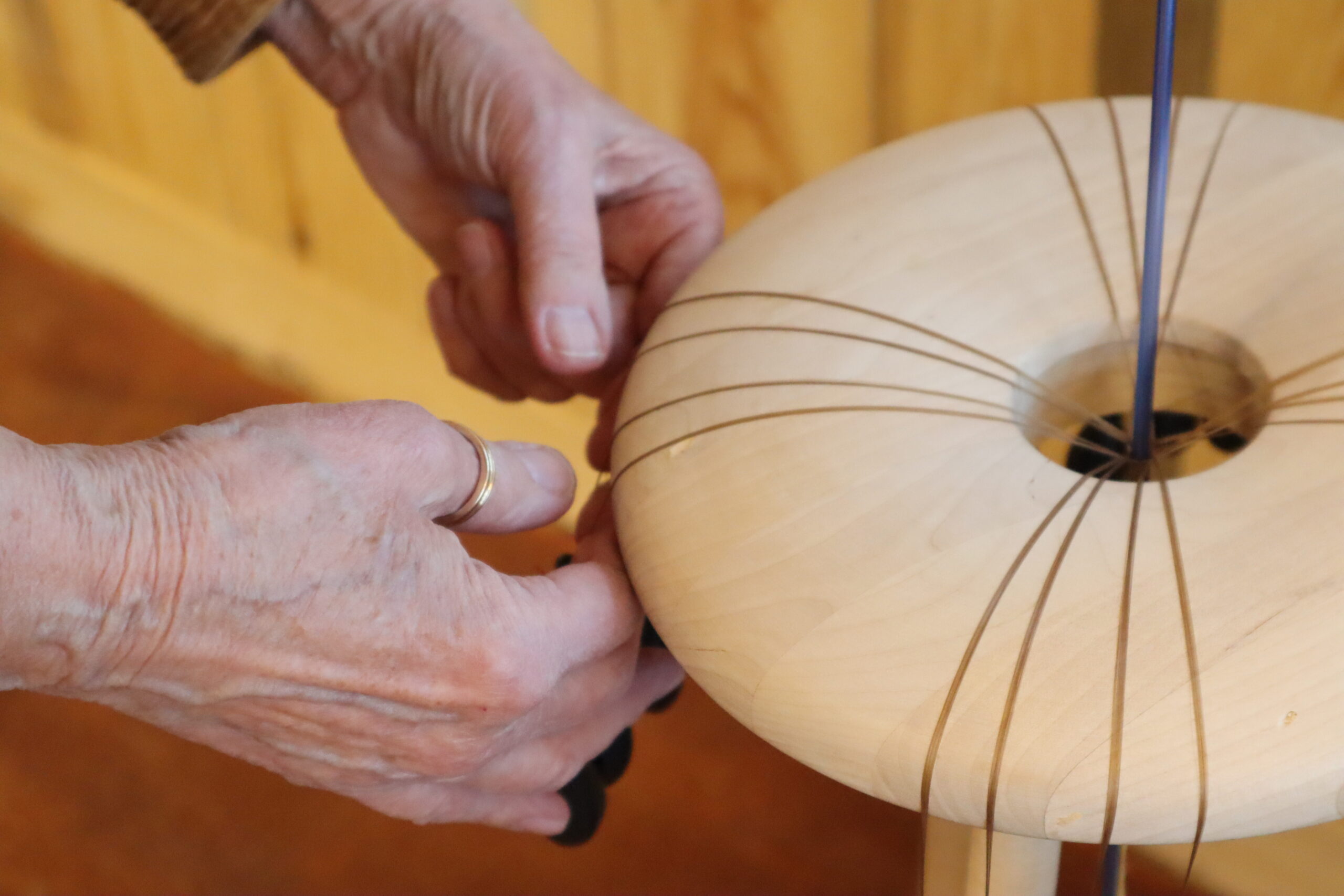 A person's light skinned hands work at a craft.