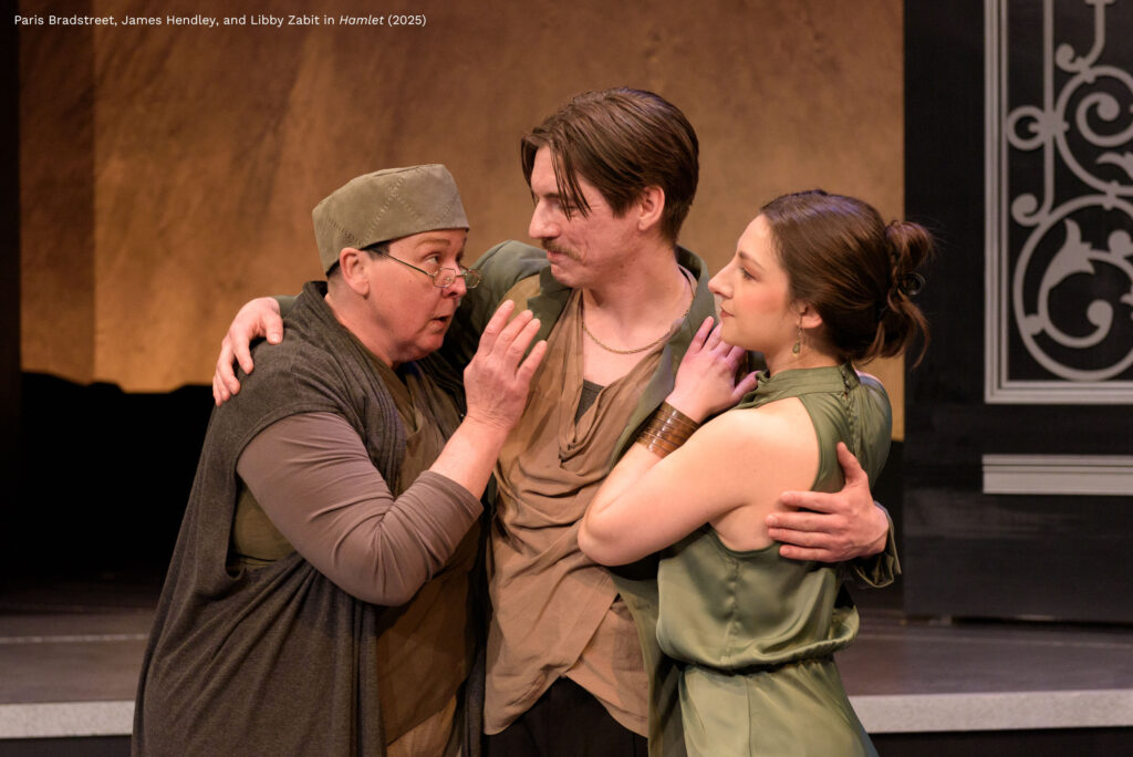 Three people embrace as the person on the left speaks and the other two pay attention.