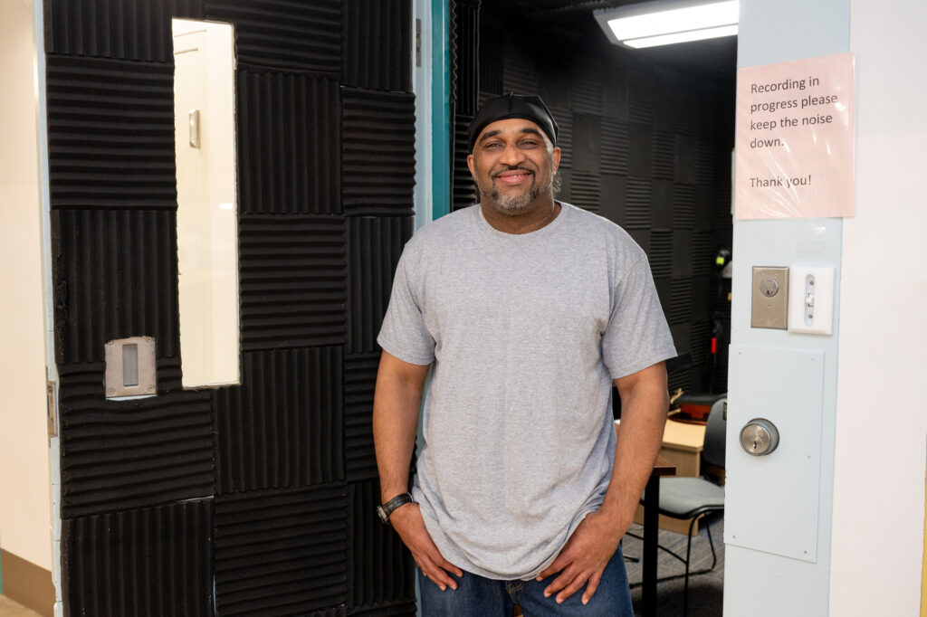 A person standing a doorway and smiling